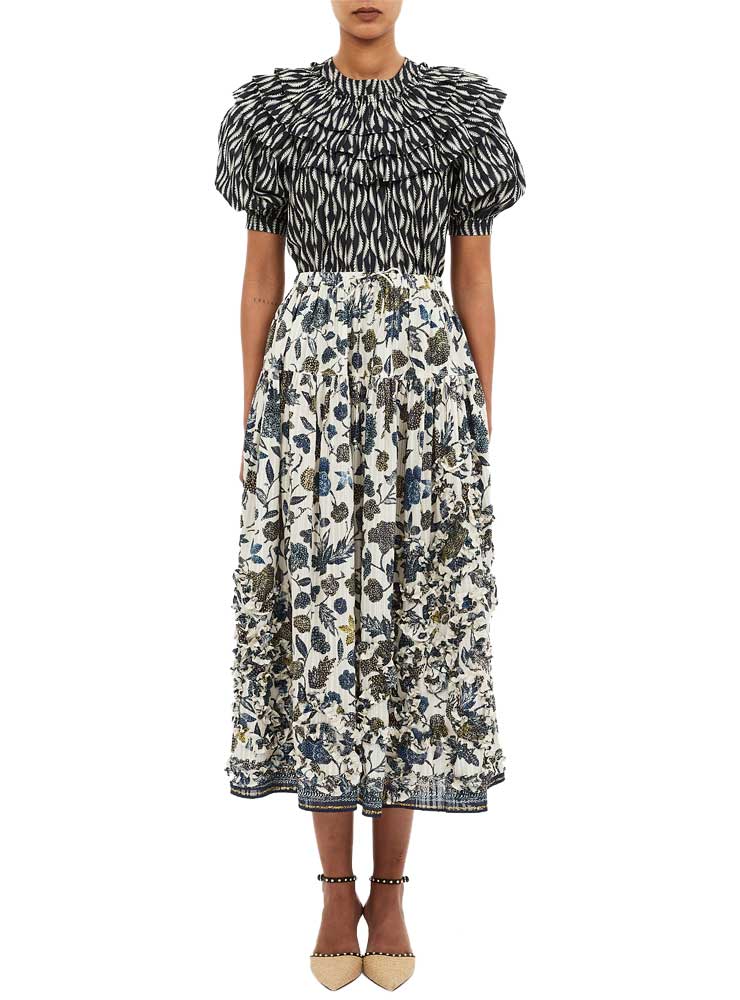 Ulla Johnson Alexandra Ruffled Skirt porcelainRuffle-detaljerne tilføjer volumen uden at virke tunge, og hver bevægelse giver nederdelen et let svaj, der fremhæver dens feminine karakter. Porcelain-nuancen fungerer som en rolig base, der kan styles med både lyse og mørke toner alt efter sæson og stemning. Denne farve fremhæver stoffets struktur og giver en ren, elegant helhed, som gør nederdelen velegnet til alt fra en simpel hverdagsbluse til en smuk silkecami eller en let strik. Kvaliteten er som altid gennemført hos Ulla Johnson, hvor valget af materialer og konstruktion spiller en central rolle. Selvom denne model varierer i tekniske detaljer fra kollektion til kollektion, er der en tydelig rød tråd: lethed, smukt fald og en behagelig fornemmelse mod huden. Det gør nederdelen anvendelig både i varme måneder og som del af et lag-på-lag look i de køligere sæsoner. Hos Cristels finder du et kurateret udvalg af Ulla Johnson styles, der kombinerer moderne femininitet med naturlige farver og luksuriøse materialer. Se hele udvalget her: https://cristels.dk Ulla Johnson Alexandra Ruffled Skirt Porcelain er et elegant og alsidigt item, der tilfører garderoben et blødt, romantisk udtryk med en tidløs silhuet. Perfekt til sæsoner, hvor lethed og luksus går hånd i hånd.